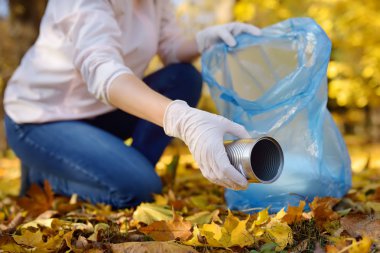 Metal çöp ve açık havada üzerinde biyolojik olarak parçalanabilen çöp kutusuna koyarak gönüllü. Ekoloji, geri dönüşüm ve doğa kavramı korunması.