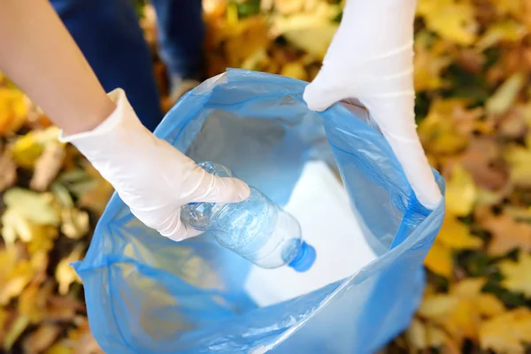 Gönüllü plastik çöp ve açık havada üzerinde biyolojik olarak parçalanabilen çöp kutusuna koyarak. Ekoloji, geri dönüşüm ve doğa kavramı korunması.