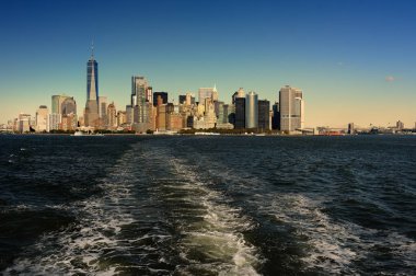 Gün batımında Manhattan ve Doğu Nehri ünlü gökdelenler ile tonda manzarası. Su Tur Özgürlük Adası.