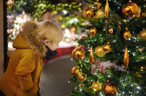 小男孩附近的圣诞树装饰金球户外 大城市的传统圣诞市场 — 图库照片