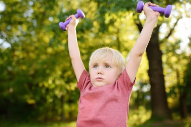 Sevimli küçük çocuk açık havada halter kaldırma. Çocuğun spor.