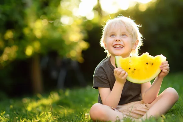Cute Caucasian Little Boy Blond Hairs Eating Yellow Watermelon Outdoors — Stock Photo, Image