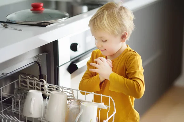 Child Puts Dirty Crockery Home Dishwasher Close Mom Little Helper — Stock Photo, Image