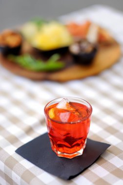 İtalyan aperitives/Aperatif: kadeh kokteyl (köpüklü şarap Aperol ile) ve meze tabağı masanın üzerinde. Geleneksel İtalyan mutfağı.