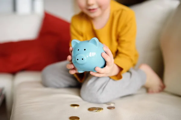 Маленький хлопчик дивиться на грошову скриньку і плани того, що він може купити . — стокове фото