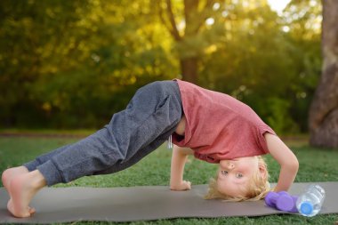 Küçük çocuk streç yapmak egzersiz açık havada sırasında. Çocuklar için sağlıklı yaşam tarzı.