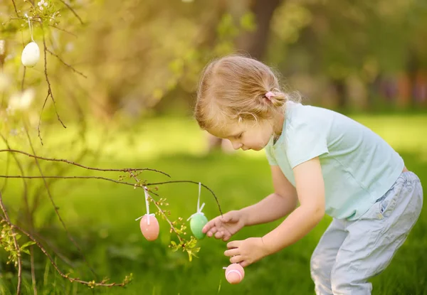 可爱的小女孩在开花的树枝上寻找复活节彩蛋 户外传统复活节 — 图库照片