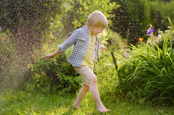 Забавный Маленький Мальчик Играет Садовый Разбрызгиватель Солнечном Заднем Дворе Ребенок — стоковое фото