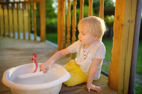 Милый Маленький Мальчик Играет Самодельным Кораблем Бассейне Воды Крыльце Дома — стоковое фото