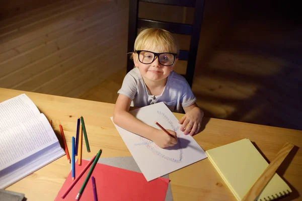 Маленький Хлопчик Окулярах Робить Домашнє Завдання Малює Пише Вдома Ввечері — стокове фото