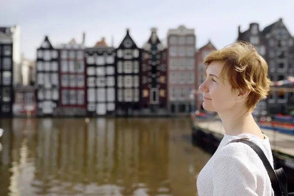 在阳光明媚的日子里 成熟的女人看着阿姆斯特丹著名的舞蹈屋 荷兰人的观光 荷兰的旅游和旅游 — 图库照片