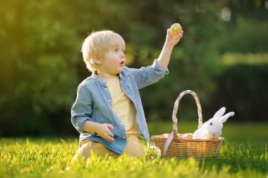 Paskalya yumurtası bahar Park için Paskalya gününde avcılık büyüleyici küçük çocuk.