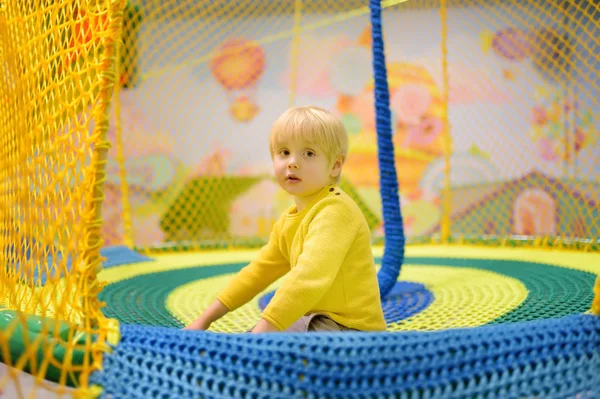 Fröhlicher kleiner Junge, der sich im Spielzentrum amüsiert. Kind spielt auf Indoor-Spielplatz. — Stockfoto