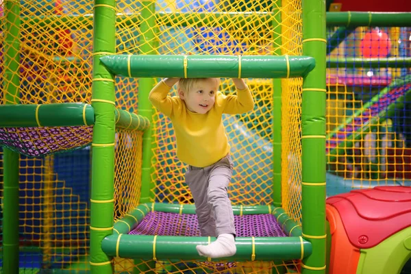 Mutlu küçük çocuk da eğlence Oyun Merkezi eğleniyor. Kapalı sahada oynayan çocuk. — Stok fotoğraf