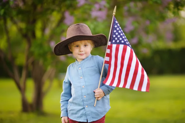 Милий маленький хлопчик тримає американський прапор у прекрасному парку . — стокове фото