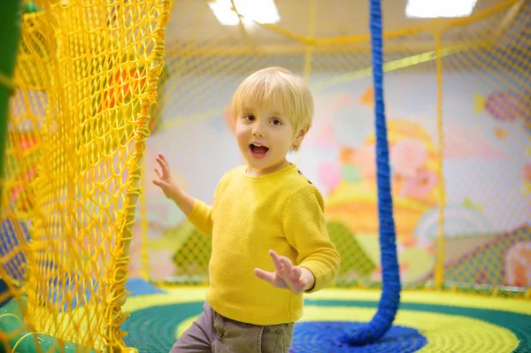 Fröhlicher kleiner Junge, der sich im Spielzentrum amüsiert. Kind spielt auf Indoor-Spielplatz. — Stockfoto