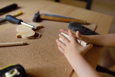 Küçük çocuk iş araçları ile öğrenir. Çocuk ahşap oyuncak olun. Yakın çekim. Geleneksel eğitim çocuk. Aile değerleri. Babamın yetiştirme.