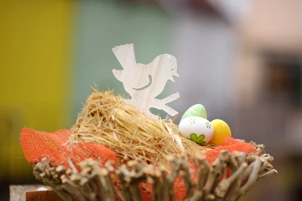 Easter decorations on the street of small town in France. Easter painted eggs and bird in nest. Garden decor. — Stock Photo, Image