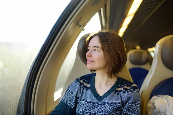 Portret van een mooi peinzende meisje droomt in een trein auto. — Stockfoto