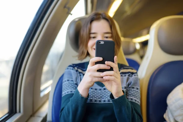 Portret van een mooi meisje die communiceren via de telefoon in de auto van een trein. Mobiele communicatie - de vreugde van de mededeling van overal — Stockfoto