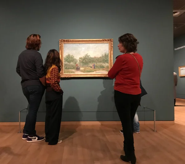 AMSTERDÃO, PAÍSES BAIXOS - 19 DE MARÇO DE 2019: Visitantes olham para as pinturas de Vincent van Gogh no Museu Van Gogh, em Amsterdã, Holanda. Foto móvel . — Fotografia de Stock