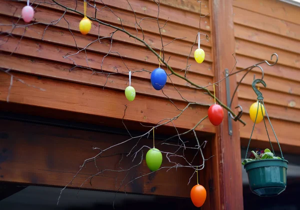 Easter decorations on the street of small town in France. Easter painted eggs hanging on a branch of tree. — Stock Photo, Image
