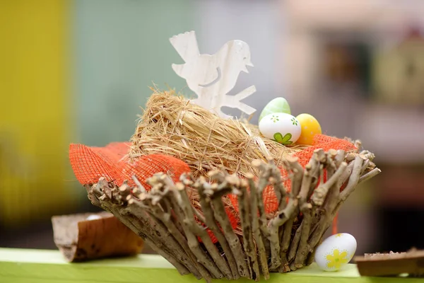 Easter decorations on the street of small town in France. Easter painted eggs and bird in nest. Garden decor. — Stock Photo, Image