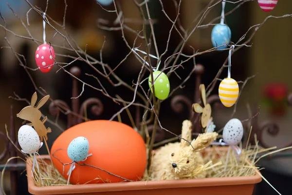 Easter decorations on the street of small town in France. Easter painted eggs hanging on a branch of tree. — Stock Photo, Image