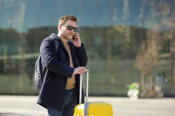 Mann mittleren Alters telefoniert im Hintergrund des Hauptbahnhofs. — Stockfoto