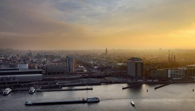 Gün batımında Amsterdam Cityscape üst görünümü. Gemiler, tekneler, Merkez İstasyon ile nehir. Hollandalı gezileri.