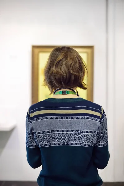 Visitor looks at the paintings in the art gallery or museum.