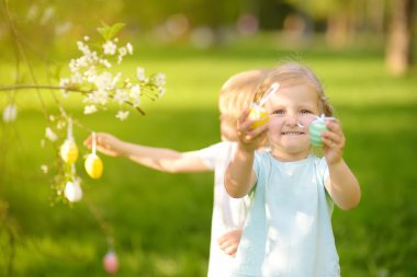 Sevimli küçük çocuklar Paskalya gününde bahar parkında boyalı yumurta için avlar.