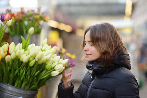 Hermosa joven mujer seleccionando tulipanes frescos en el famoso mercado de flores de Ámsterdam (Bloemenmarkt ). —  Fotos de Stock