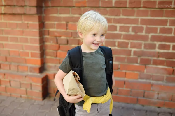 Student with big backpack and lunch bag near the school building — Stock Photo, Image