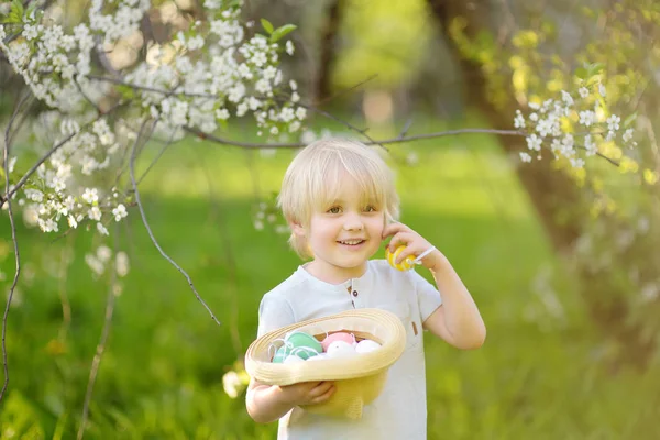 Charmante kleine jongen op jacht naar Paasei in park voorjaarsbijeenkomst op Paasdag — Stockfoto