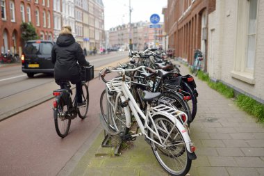 Amsterdam, Hollanda-21 Mart 2019: kadın Amsterdam merkezinde bir bisiklet sürmek. Avrupa 'nın Bisiklet başkenti.