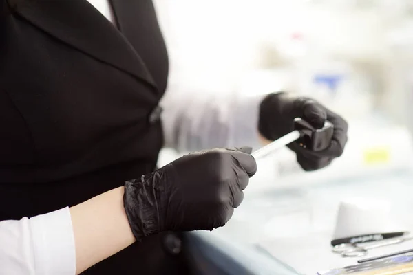 Esteticista afiar um lápis e prepara-o para uso. Cuidados faciais e maquiagem em um salão profissional . — Fotografia de Stock