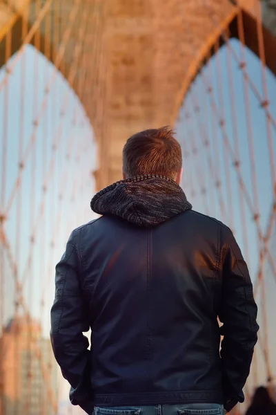 Mann auf einer berühmten Brücke bei Sonnenuntergang in New York, USA — Stockfoto