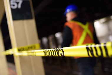 New York metrosunda tamir. Uyarı bandı arkasında Nyc metro istasyonunun platformunda Mta işçi.