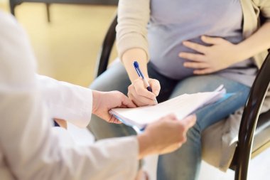 Hamile kadın jinekolog doktor kabul sırasında sözleşme veya izin imzalamak. Sağlık sigortası çocuk doğurma. Gebelik için aile doktoru. Doğum izni.