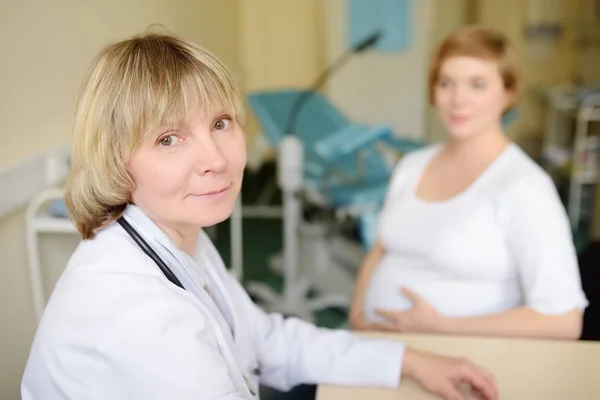 Lekarz ginekolog akceptuje kobiety w ciąży. Ubezpieczenie zdrowotne w wieku rozrodczym. Lekarz rodzinny w ciąży. Leve macierzyństwa. — Zdjęcie stockowe