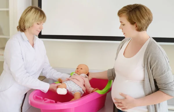 Mujer embarazada en cursos de lecciones para mujeres embarazadas. Seguro médico de maternidad. Médico de familia para la gestación. Permiso de maternidad. Pediatría . — Foto de Stock