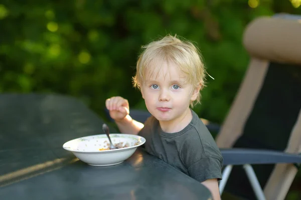 小さな男の子は彼の家の庭で朝食シリアルを食べる. — ストック写真