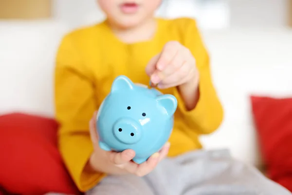 Little boy putting coin into piggy bank. — Stock Photo, Image