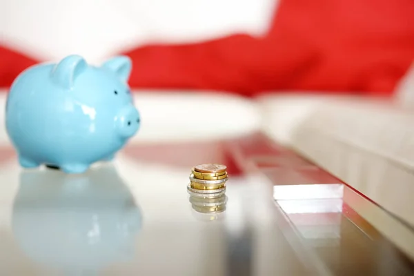 Blue piggy bank and coins on table in living room. Education of children in financial literacy. — Stock Photo, Image