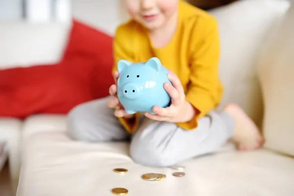 Little boy putting coin into piggy bank. — Stock Photo, Image