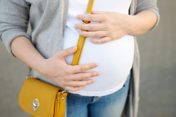 Kobieta w ciąży jest chodzenie w mieście lub zrobić zakupy. Urlop macierzyński. Moda i Ciąża. — Zdjęcie stockowe