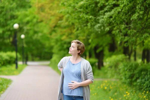 Portret pięknej młodej kobiety w ciąży w parku wiosennym — Zdjęcie stockowe