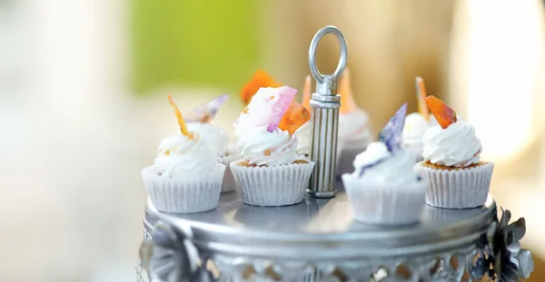 Deliciosos cupcakes de boda coloridos con flor y mariposa y hermoso pastel esmaltado . —  Fotos de Stock