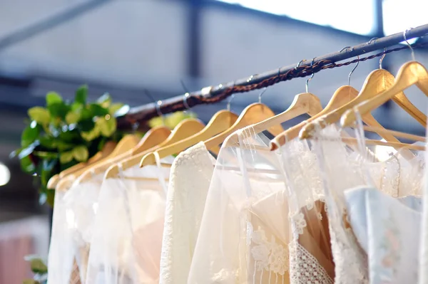 Peu d'élégantes robes de mariée, de demoiselle d'honneur, de soirée, de bal ou de bal sur un cintre dans un magasin de mariage . — Photo